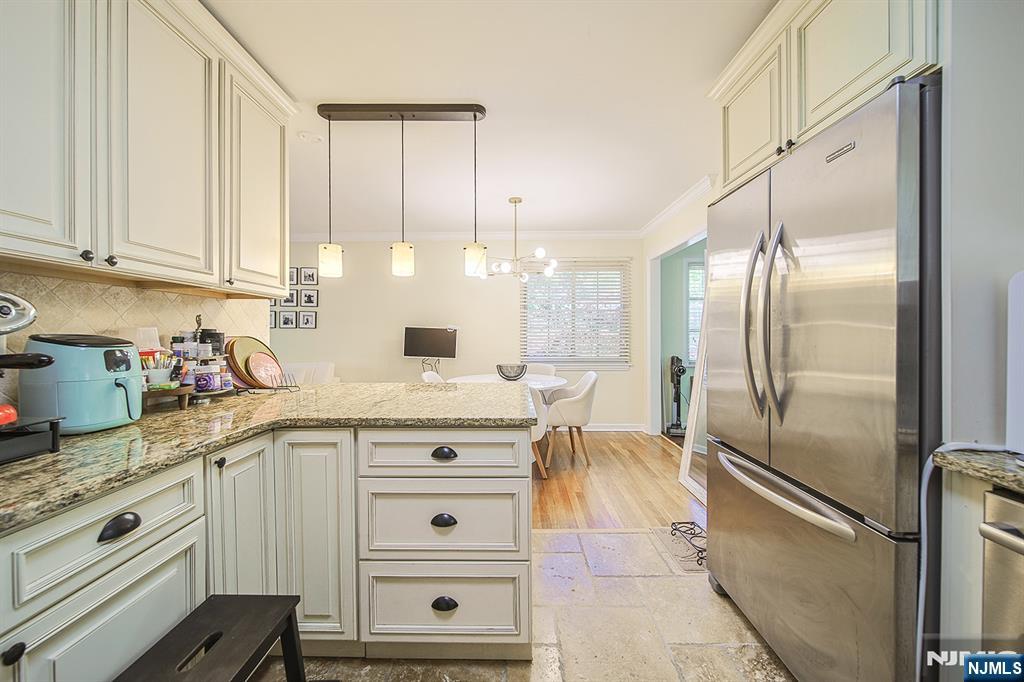 181 Crescent Street Closter, NJ 07624 - Photo 16 of 25 a kitchen with granite countertop a refrigerator a sink and cabinets