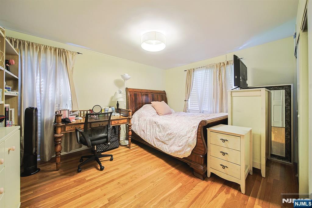 181 Crescent Street Closter, NJ 07624 - Photo 22 of 25 a bedroom with furniture and a wooden floor