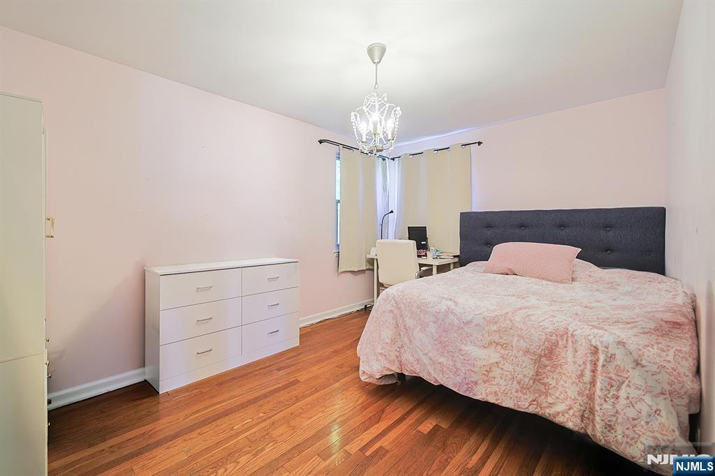 181 Crescent Street Closter, NJ 07624 - Photo 23 of 25 a bedroom with a bed and a chandelier