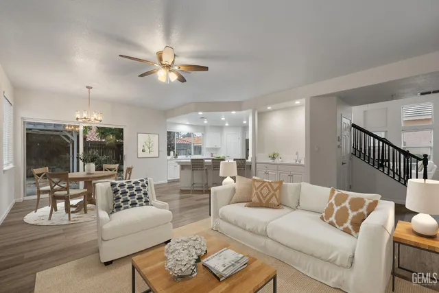 a living room with furniture ceiling fan and a flat screen tv