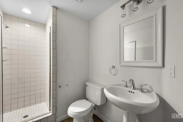 a bathroom with a sink a toilet and shower