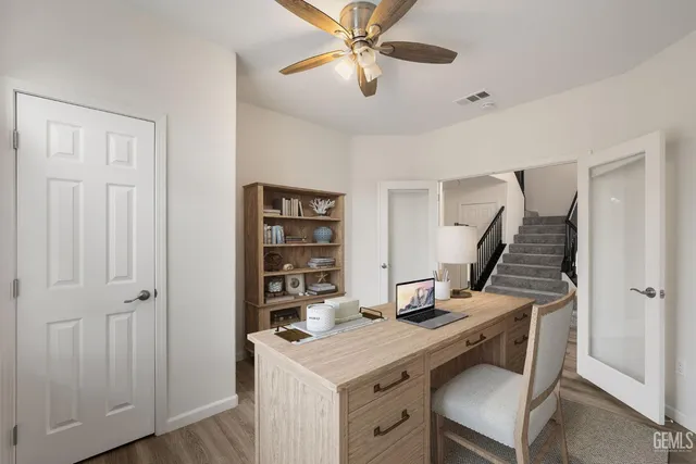 a view of a workspace with furniture and a window
