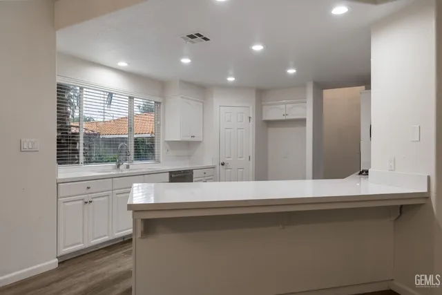 a view of a kitchen with a sink and wooden floor