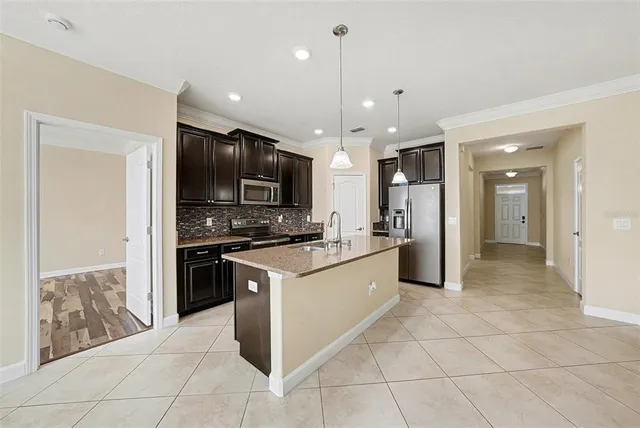 a kitchen with kitchen island granite countertop a stove cabinets and refrigerator