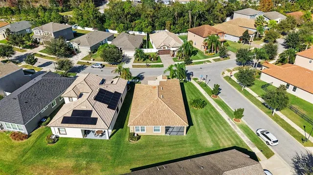 an aerial view of a residential houses with yard