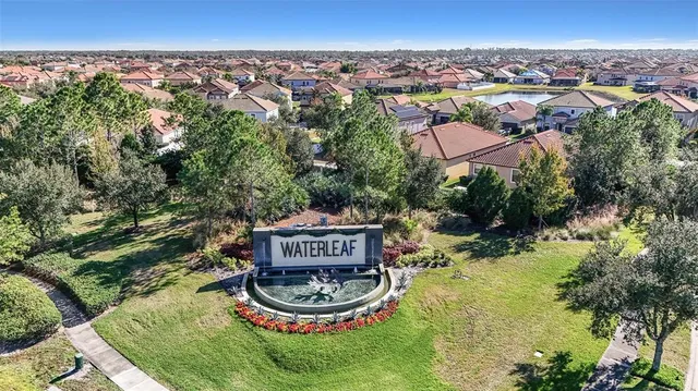 a view of a white house with a big yard and large tree