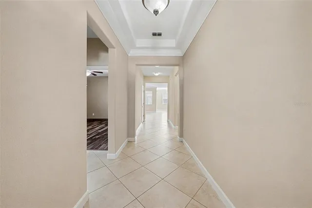 a view of a hallway with wooden floor and a bathroom
