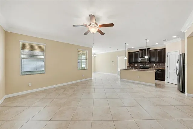 a view of a kitchen with a stove cabinets a ceiling fan and wooden floor
