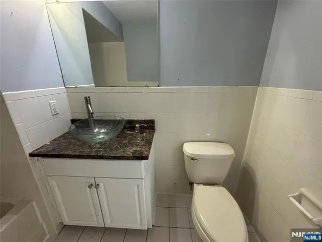a bathroom with a granite countertop toilet and a sink