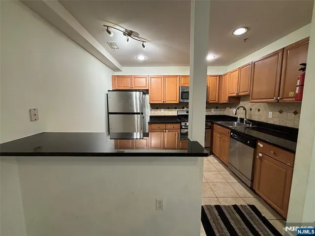 a kitchen with stainless steel appliances a sink stove and refrigerator