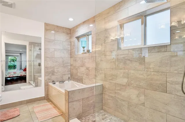a bathroom with a tub a sink and mirrors