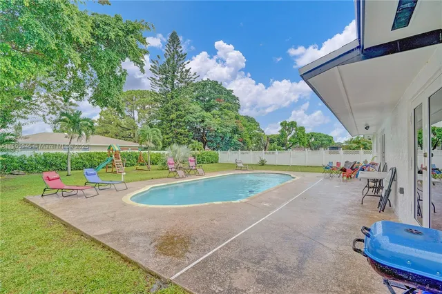 swimming pool view with a garden space
