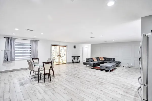 a living room with furniture a dining table and wooden floor