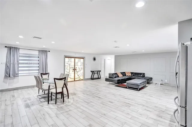 a living room with furniture a dining table and wooden floor