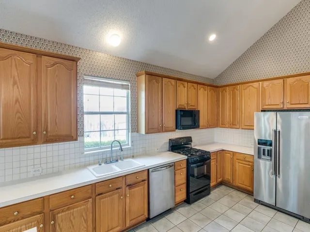 a kitchen with a sink stove and refrigerator