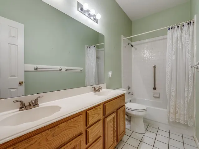 a bathroom with a granite countertop sink a toilet a mirror and shower