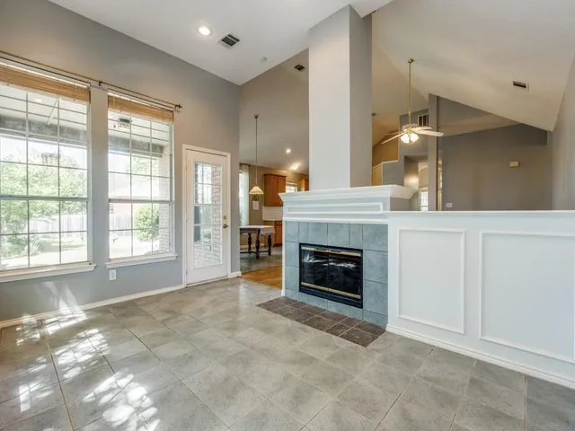 a view of an empty room with a fireplace and a window