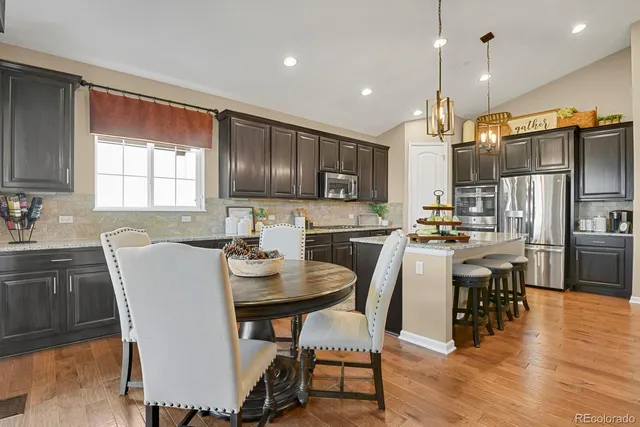 a kitchen with a table chairs refrigerator and microwave