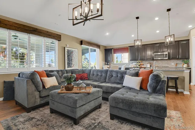 a living room with furniture kitchen and a chandelier