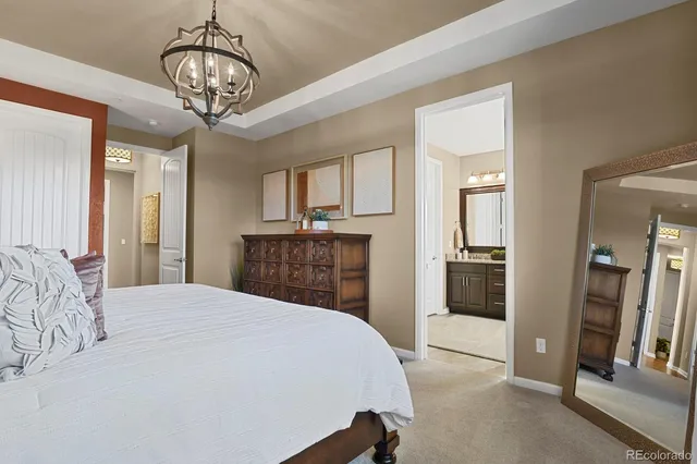 a bedroom with a large bed and a chandelier