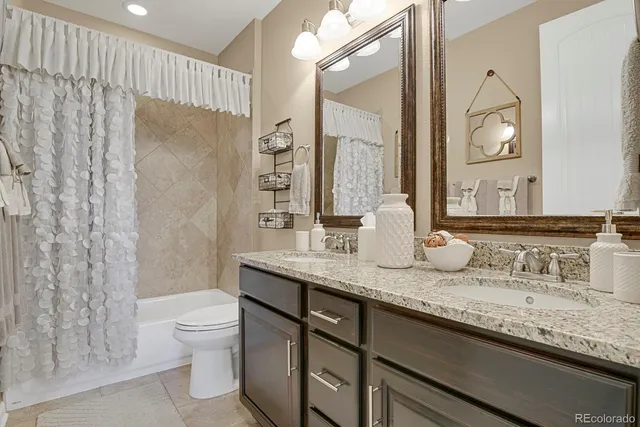 a bathroom with a granite countertop sink a toilet and a mirror