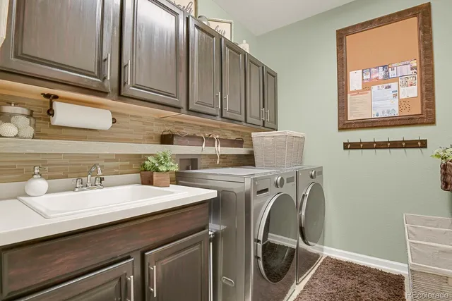 a utility room with a sink washer and dryer