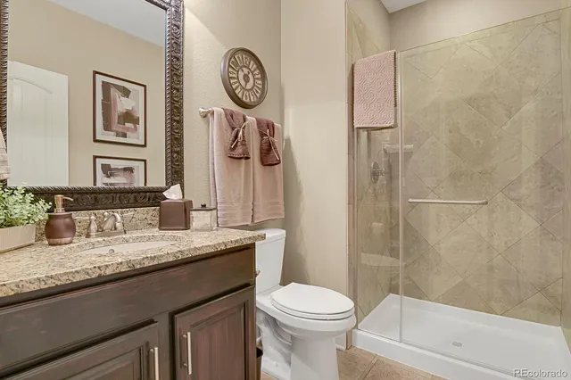 a bathroom with a granite countertop sink toilet and shower