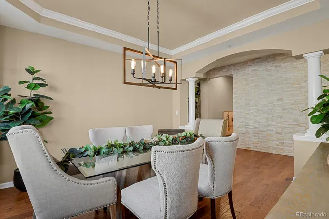 a dining room with furniture potted plants and wooden floor