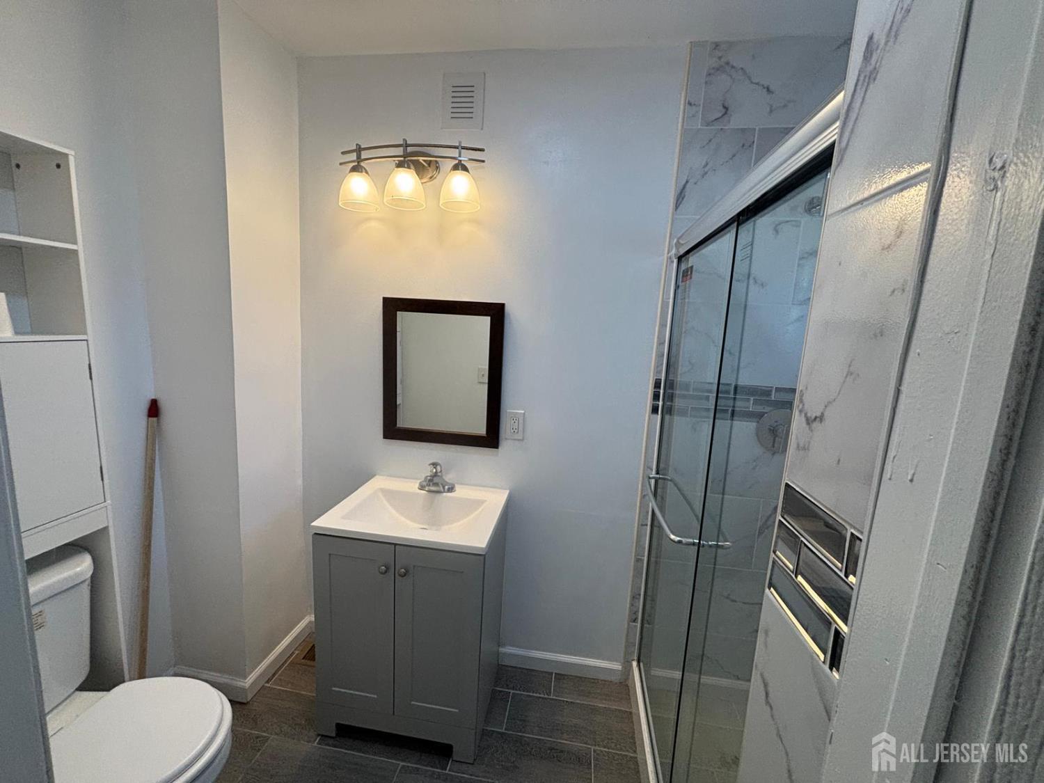 220 South Washington Avenue Dunellen, NJ 08812 - Photo 5 of 21 a bathroom with a toilet sink and mirror