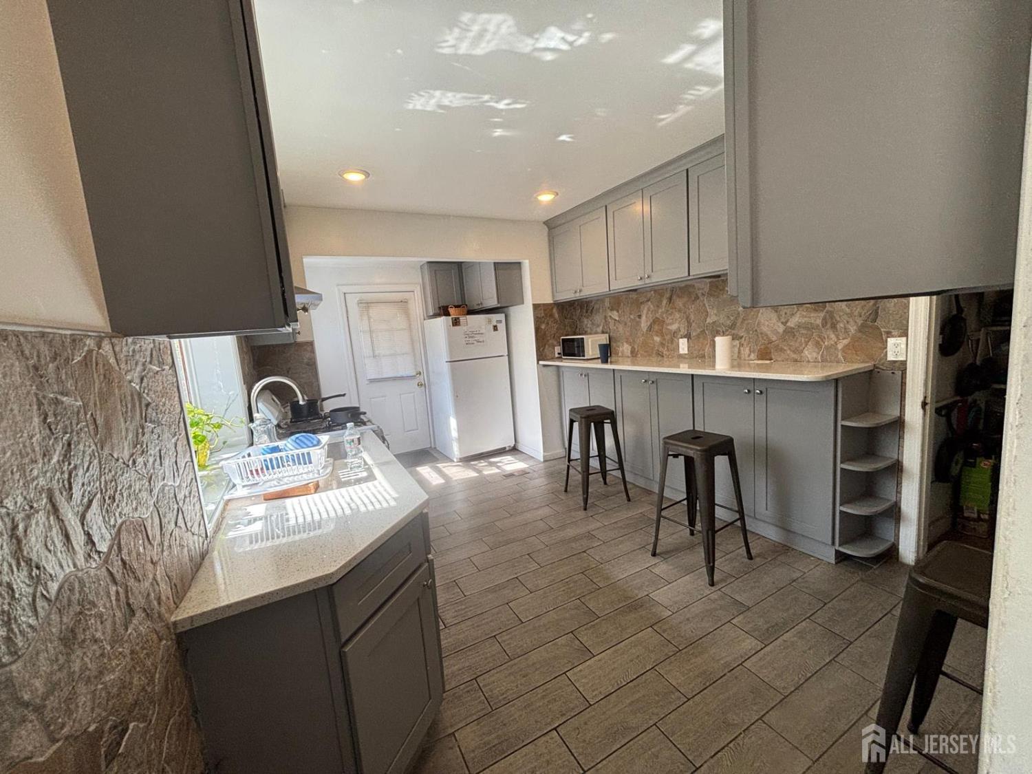 220 South Washington Avenue Dunellen, NJ 08812 - Photo 10 of 21 a kitchen with kitchen island a sink stove and cabinets