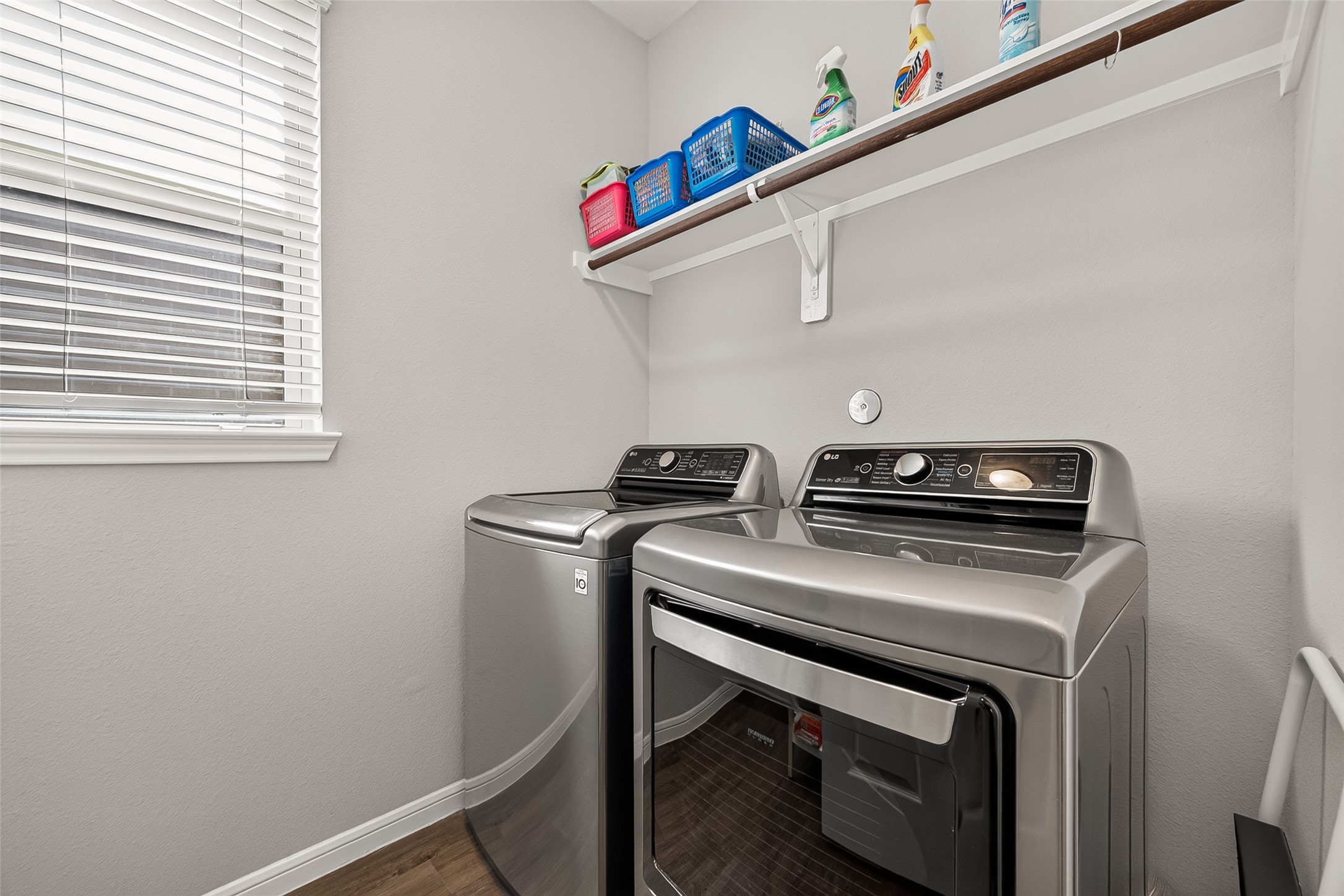1329 Red Hills Drive Rosharon, TX 77583 - Photo 22 of 27 A spacious a modern laundry room. The space includes a window with blinds for natural light and a shelf above for storage. The walls are painted a neutral color, complementing the home.