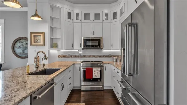 a kitchen with stainless steel appliances granite countertop a stove a sink and a microwave