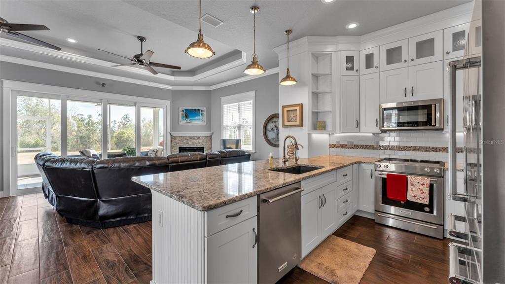 3272 Fish Hawk Drive Polk City, FL 33868 - Photo 12 of 38 a kitchen with stainless steel appliances granite countertop a stove a sink and a microwave