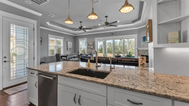 a living room with furniture a clock potted plant and a large window