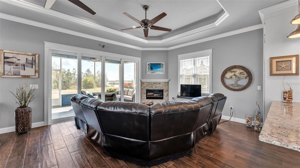 3272 Fish Hawk Drive Polk City, FL 33868 - Photo 15 of 38 a living room with furniture a clock potted plant and a large window