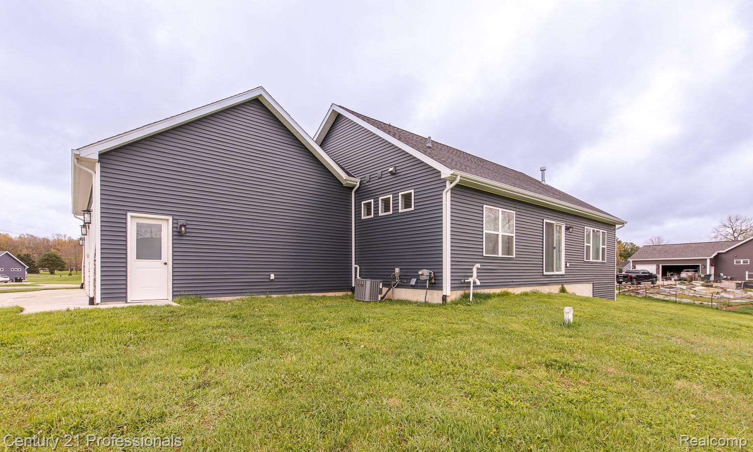 4914 TORATOLA Lane Howell, MI 48843 - Photo 33 of 39 View of property exterior featuring a yard