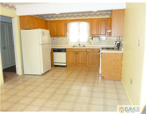 24 Summerall Road Somerset, NJ 08873 - Photo 15 of 24 a kitchen with a refrigerator a stove a sink and a dining table