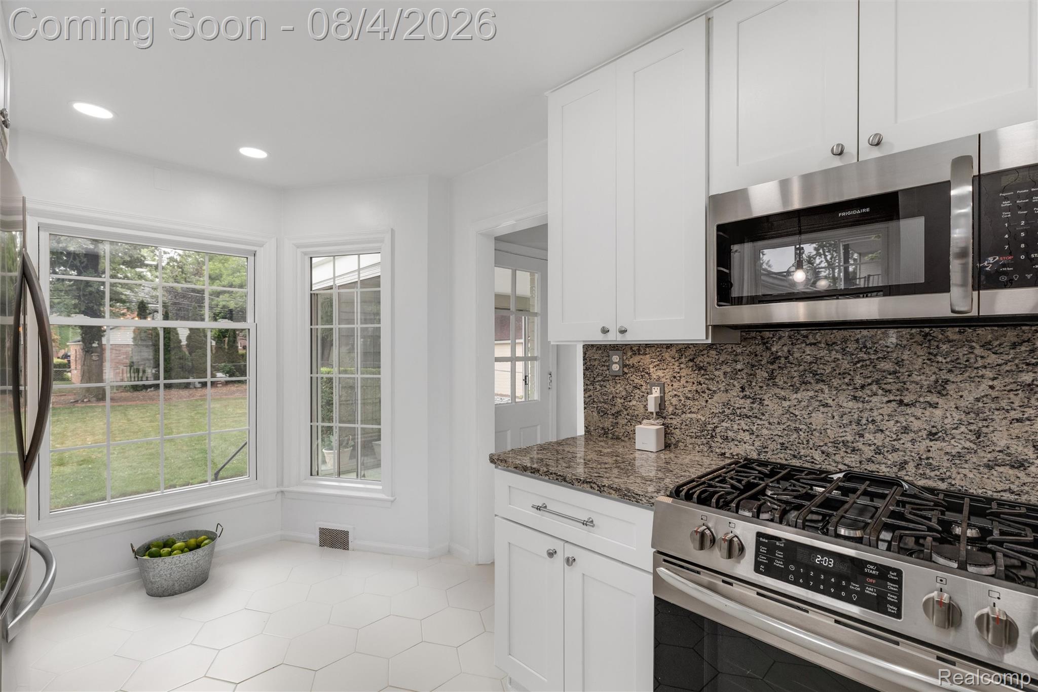 1729 Broadstone Road Grosse Pointe, MI 48236 - Photo 11 of 39 Kitchen featuring white cabinetry, granite countertops, stainless steel gas range, and a built-in microwave