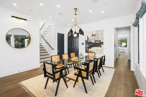 a view of a dining room and livingroom with furniture wooden floor a chandelier