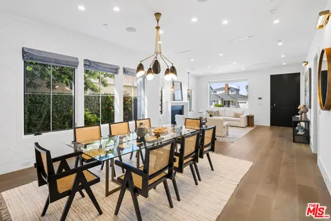 a view of a dining room and livingroom with furniture clock and wooden floor
