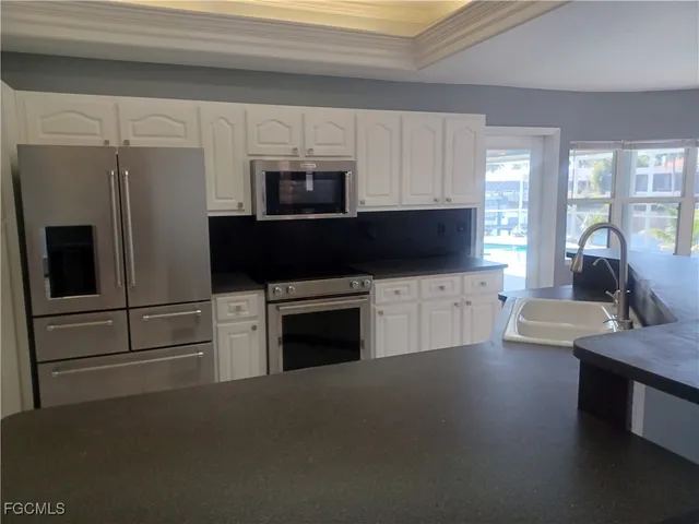 a kitchen with a sink a microwave and cabinets