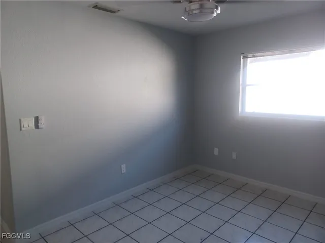 an empty room with closet and a chandelier fan