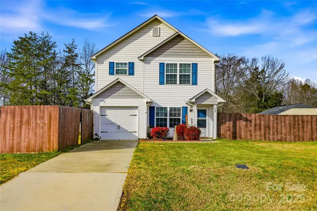 a view of a house with yard and fence