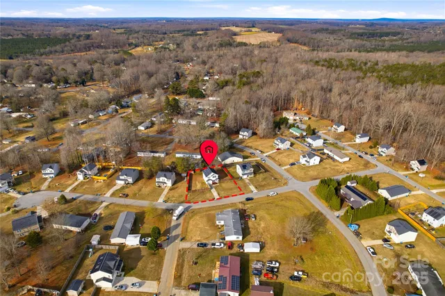a view of a house with wooden fence next to a yard