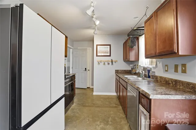 a kitchen with granite countertop a sink stove and refrigerator