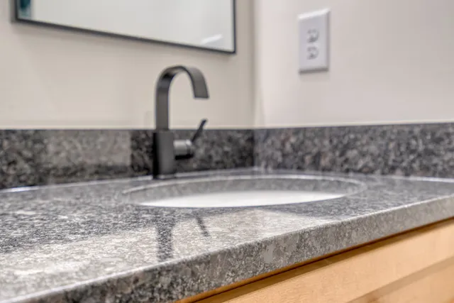 a kitchen with granite countertop a sink and a refrigerator