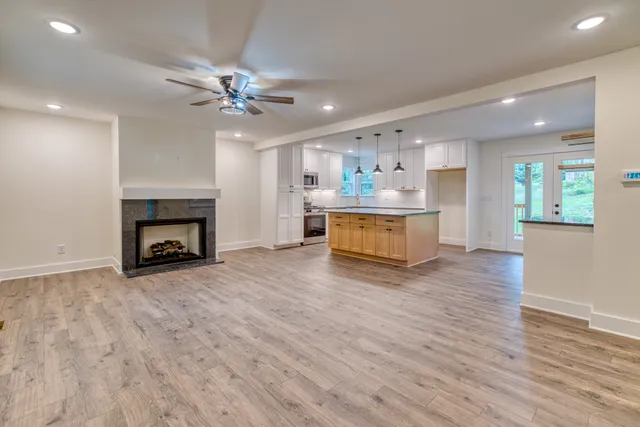 an empty room with windows and fan
