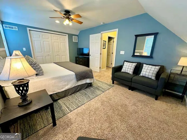 a bedroom with a bed a couch and dresser