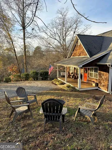 a view of swimming pool with lawn chairs and plants