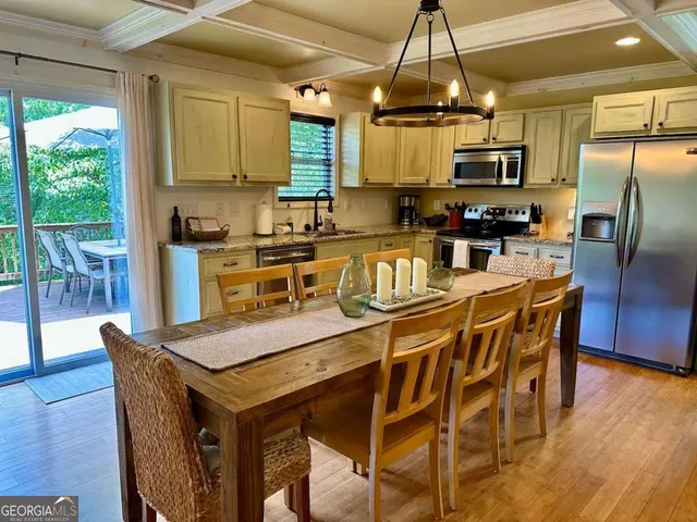 a kitchen with stainless steel appliances granite countertop a kitchen island a stove a table and chairs